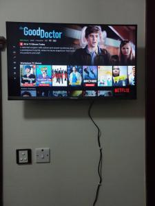 a flat screen tv hanging on a wall at GRACE BEDSPACE, HOSTEL AND ACCOMODATIONS in Dubai