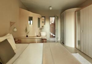 a bedroom with a large white bed and a bathroom at F Zeen in Lourdata