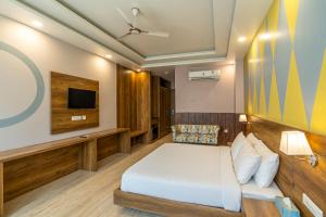 a hotel room with a bed and a tv at Moustache Rishikesh Luxuria in Rishīkesh