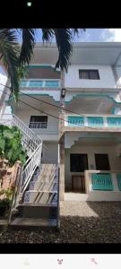 a white building with stairs in front of it at Rosita's Cottages by the Road in Moalboal