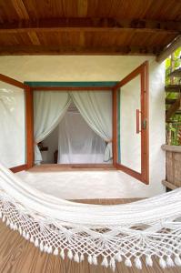 a hammock in front of a bedroom with a window at Caiçara Bangalôs Barra Grande in Barra Grande