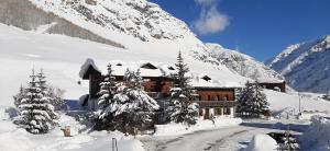 ein schneebedecktes Gebäude auf einem schneebedeckten Berg in der Unterkunft Chalet Del Sole per gruppi in Livigno