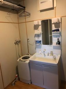 La salle de bains est pourvue d'un lavabo et d'un lave-linge. dans l'établissement Rental room Narita "Male Only" - Vacation STAY 58820v, à Kutchan