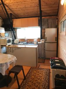 La cuisine est équipée d'un évier, d'un réfrigérateur et d'une table. dans l'établissement Rental room Narita "Male Only" - Vacation STAY 58820v, à Kutchan