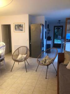 a living room with two chairs and a refrigerator at Les Lucioles in Vidauban