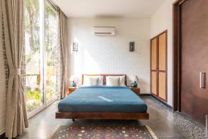 - une chambre avec un lit et une grande fenêtre dans l'établissement La Macedo Estate, à Mapusa