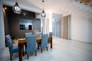 a dining room with a wooden table and blue chairs at The Breeze Residence, Kottawa in Kottawa