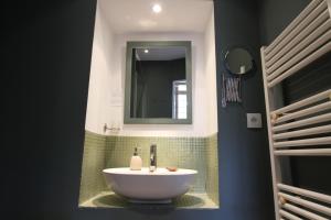 a bathroom with a white sink and a mirror at La Haute Flourie - bed and breakfast -chambres d'hôtes in Saint Malo