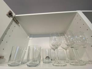 a row of wine glasses sitting on a shelf at Komfortowe apartamenty w centrum Wrocławia in Wrocław