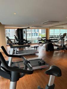 a gym with several tread machines in a room at Podomoro City Deli Medan Tower Empire - Japandi Style in Medan