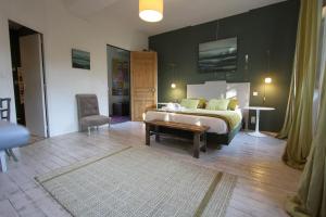 a bedroom with a bed and a table and a chair at La Haute Flourie - bed and breakfast -chambres d'hôtes in Saint Malo