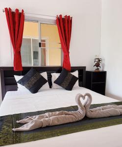 a bedroom with a bed with two swans on it at Wirason Residence in Lamai