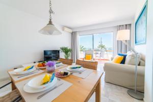 ein Wohnzimmer mit einem Tisch und einem Sofa in der Unterkunft Ideal Property Mallorca - Maritimo in Alcúdia