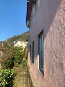 a pink building with windows on the side of it at Bata Apartment in Sarpi