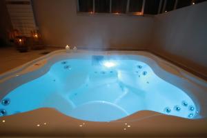 a jacuzzi tub in a room with blue lighting at La Haute Flourie - bed and breakfast -chambres d'hôtes in Saint Malo