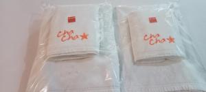 dos toallas blancas en bolsas de plástico con escritura roja. en The Bangkok Cha Cha Suite - SHA Certified, en Bangkok