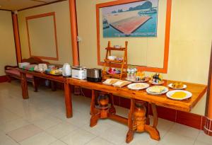 una larga mesa de madera con platos de comida. en Jamesbond Bungalow Koh Panyee, en Ko Panyi