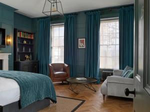 a bedroom with green walls and a bed and a chair at No131 The Promenade in Cheltenham +72 photos