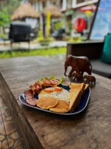 a plate of breakfast food on a wooden table at Wirason Residence in Lamai