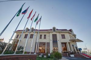 um edifício com bandeiras à sua frente em Comfort Hotel Samarkand em Samarkand