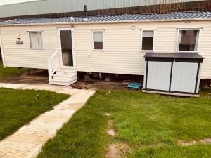 a white house with a porch and a yard at 69 Newquay bay resort Pet friendly in Newquay