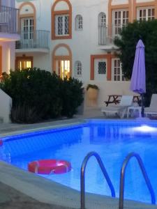 a swimming pool in front of a house at Katerina Apartments in Kalymnos