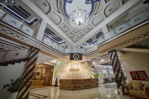 een grote lobby met een kroonluchter en een gebouw bij Comfort Hotel Samarkand in Samarkand