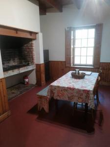 a room with a table and a window and a fireplace at Bo-Plaas Farmhouse in Bredasdorp