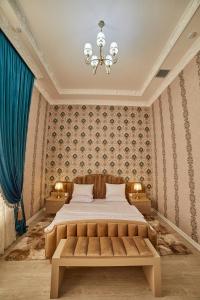 Un dormitorio con una cama grande y una lámpara de araña. en Comfort Hotel Samarkand en Samarcanda