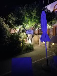 a purple umbrella in a yard at night at Katerina Apartments in Kalymnos