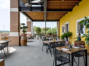 un patio al aire libre con mesas, sillas y ventanas en Agriturismo Almavite en Desenzano del Garda