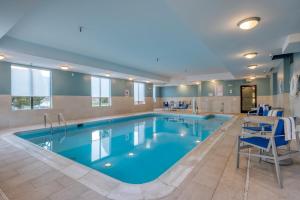 una gran piscina con agua azul en una habitación de hotel en Holiday Inn Express Hotel & Suites Thornburg-S. Fredericksburg, an IHG Hotel, en Thornburg