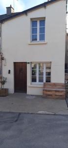 uma casa branca com um portão de madeira e uma porta em Maison des Gabelous em Guipry-Messac