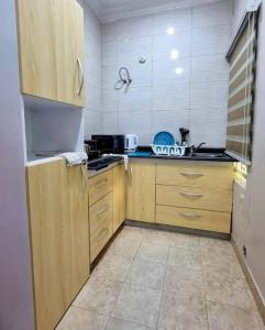 cocina con armarios de madera y encimera en Lovely 2 bedroom in osapa london, en Lekki