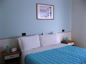 - une chambre avec un lit et une couette bleue dans l'établissement Hotel Betty, à Rimini