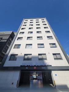 duży biały budynek z symbolem hotelu w obiekcie Hotel SUMMIT w mieście Gwangju