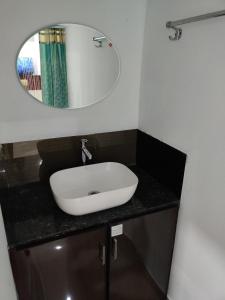a bathroom with a white sink and a mirror at Kochuparampil House in Idukki