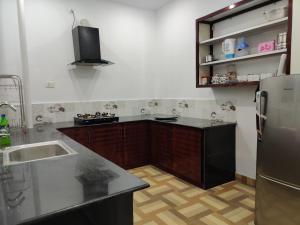 a kitchen with a black refrigerator and a sink at Kochuparampil House in Idukki