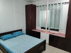 a bedroom with a bed and a window at Kochuparampil House in Idukki