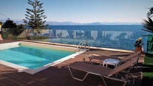 a swimming pool on a deck with a view of the water at Atena Mare Sea View in Perama