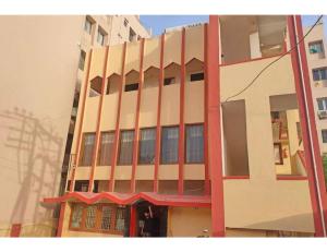 a tall building with a red awning in front of it at Hotel Anand,Junagadh in Junagadh