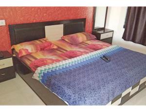 sypialnia z dużym łóżkiem z czerwoną i niebieską pościelą w obiekcie Hotel Anand,Junagadh w mieście Dźunagadh