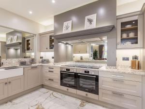 a kitchen with white cabinets and a large mirror at No3 On The Severn in Bridgnorth