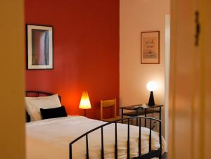 a bedroom with a bed and a red wall at 1986 Cafe & Stay in Hai Phong