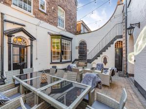 a patio with a glass table and chairs at No3 On The Severn in Bridgnorth
