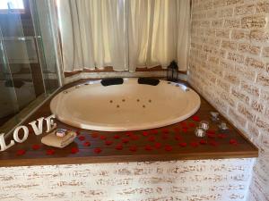 a bath tub with a bunch of red hearts around it at Chale Villa do Valle in Monte Verde