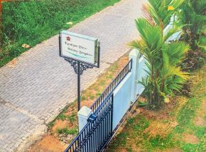 a sign in front of a fence next to a sidewalk at Kandyan View Holiday Bungalow in Kandy