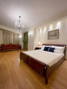 a large bedroom with a large bed and a chandelier at Villa Voulgari in Ioannina