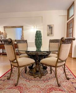 ein Esszimmer mit einem Tisch mit Stühlen und einem Kaktus in der Unterkunft Villa Voulgari in Ioannina