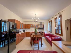a kitchen and living room with a table and a red couch at Villa Voulgari in Ioannina